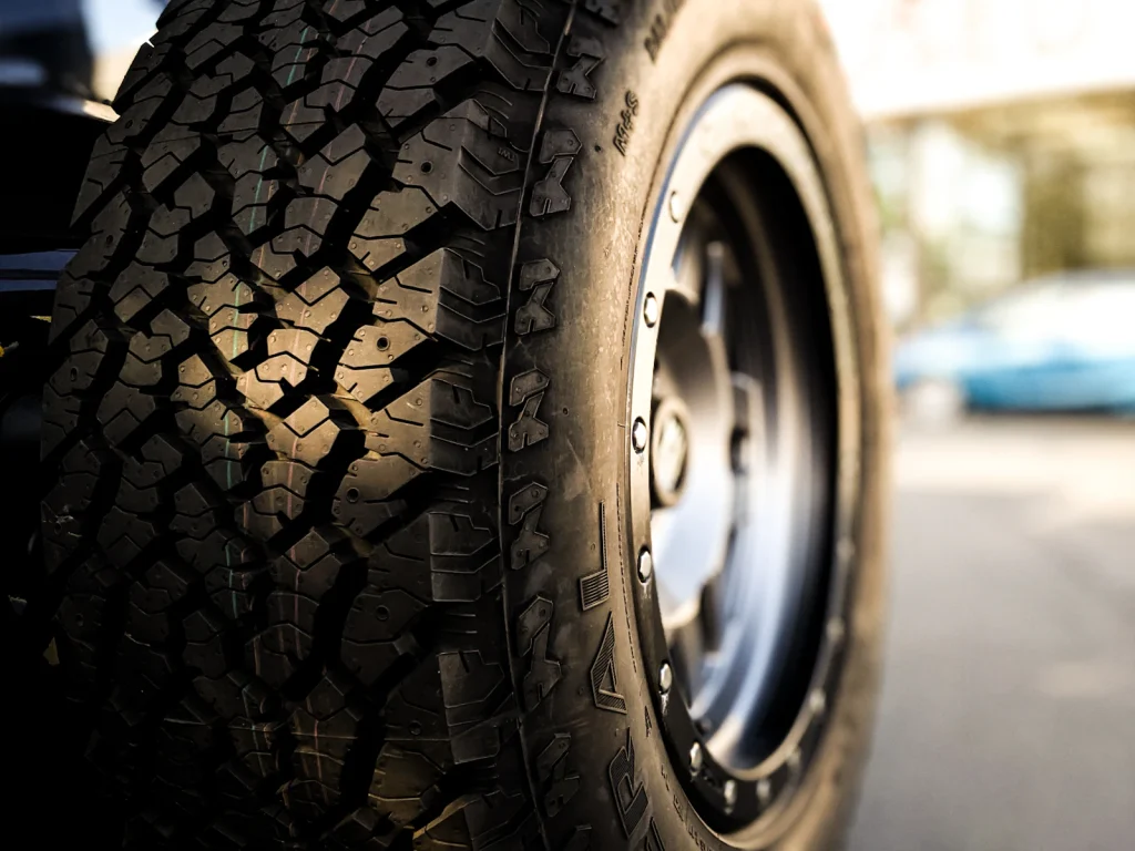 Close-up of a rugged off-road tire with deep tread and a dark metal wheel